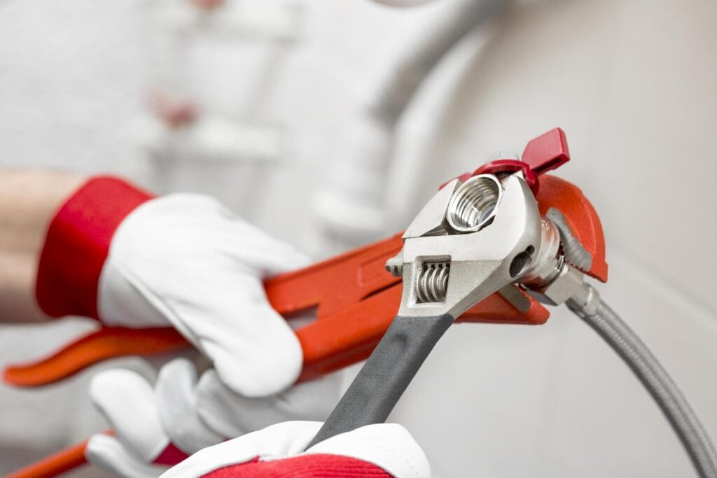 Plumber holding pipe wrenches for an emergency repair in Cape Coral