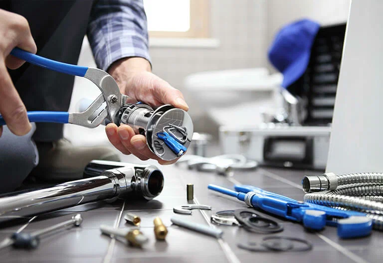 Technician repairing a plumbing fixture with professional tools in Cape Coral