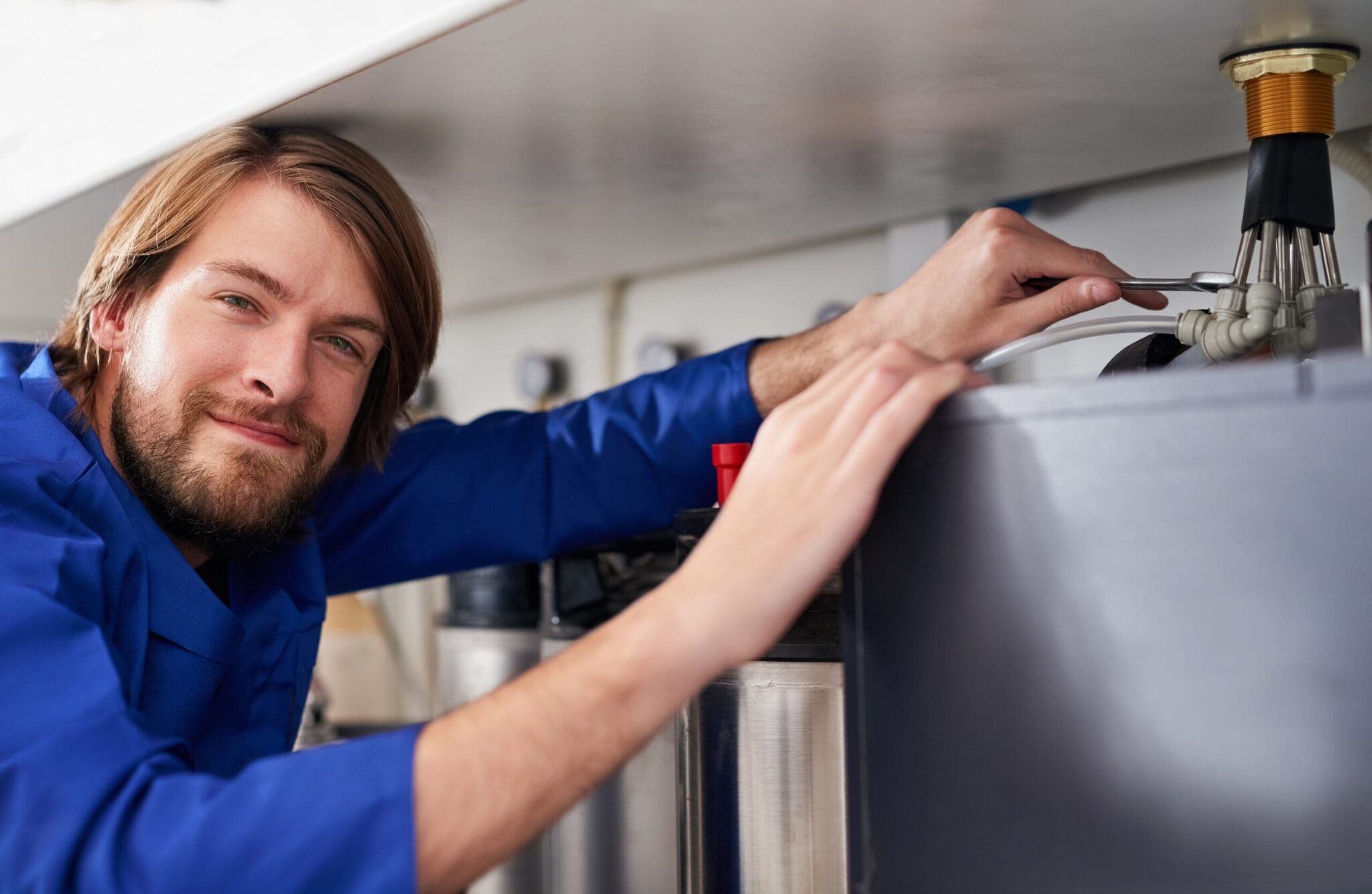 Technician servicing a residential water heater tank in Cape Coral