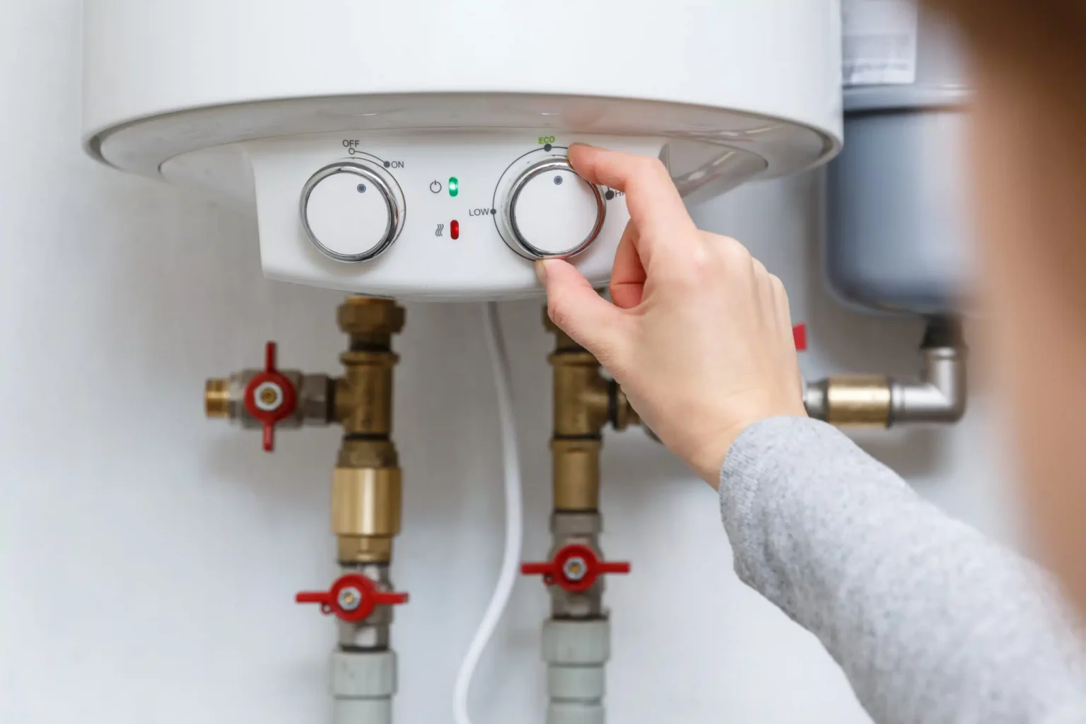 Homeowner adjusting the temperature controls on a water heater in Cape Coral
